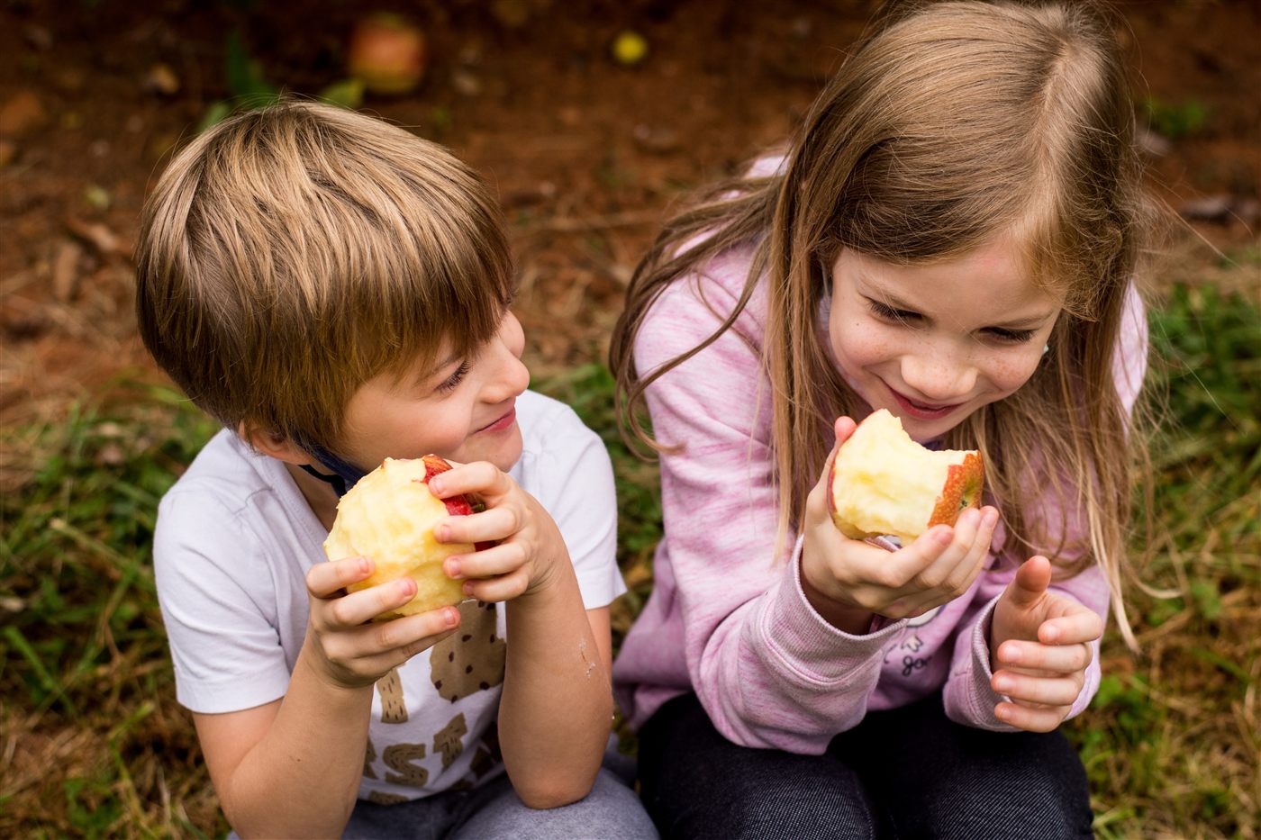 Two kids comparing apples they picked on an Ad Astra Active field trip
